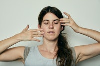 a woman covering her eyes with her hands